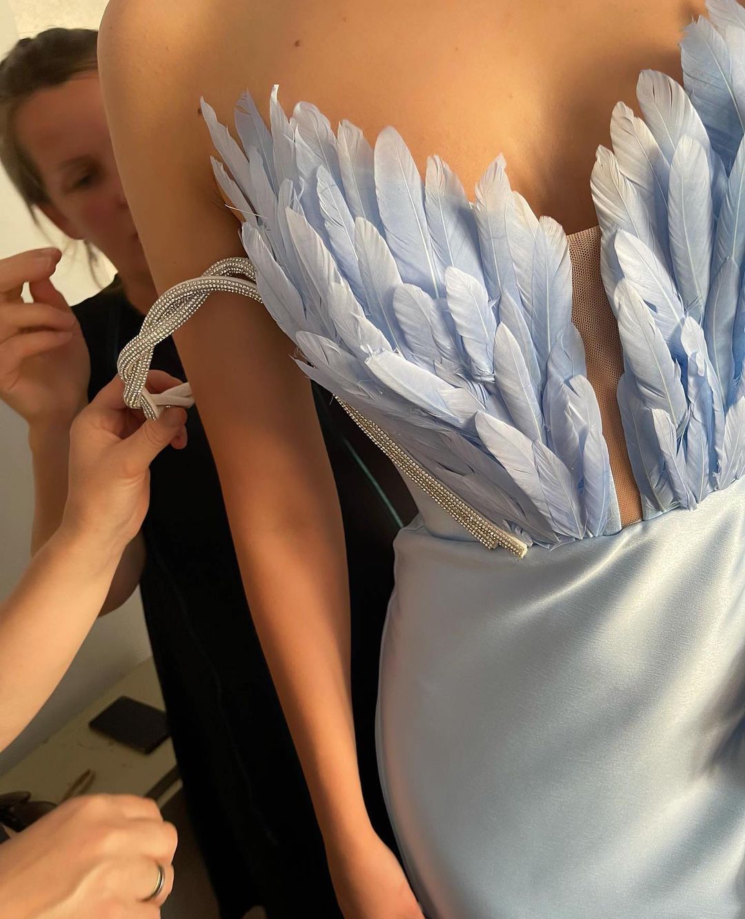 Ein Kleid mit Federn, die über den Boden fegen