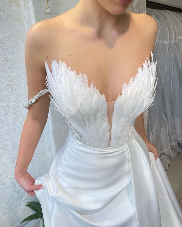 Ein Kleid mit Federn, die über den Boden fegen